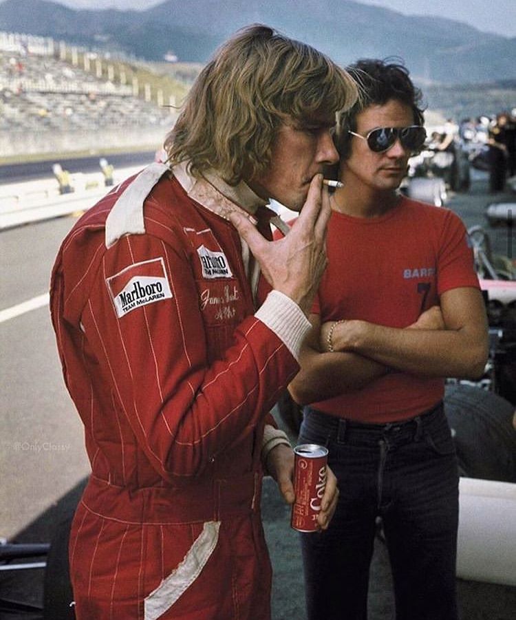 Two men watching a race from the pit lane